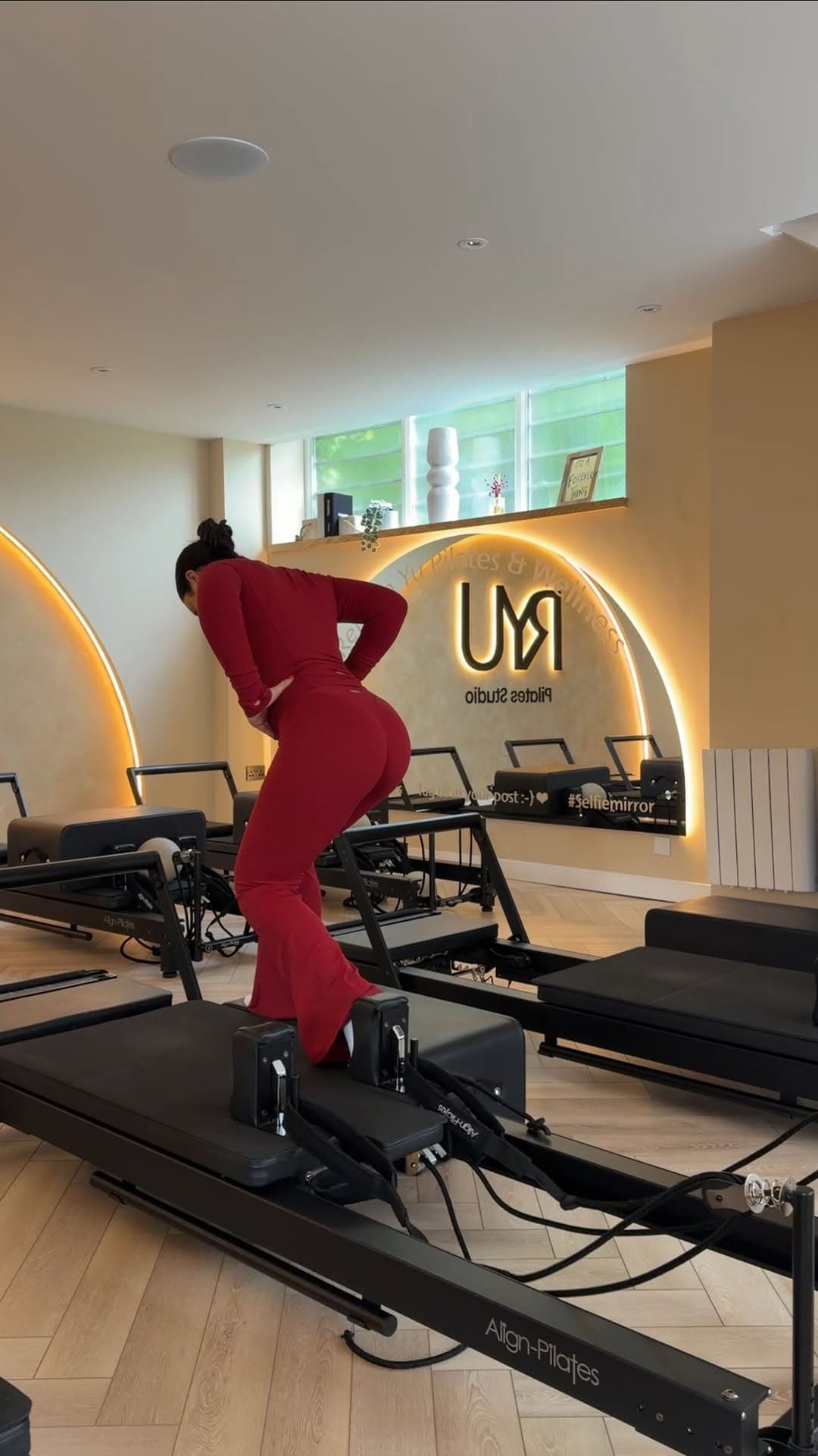 Sculpt YU — woman in red outfit performing deep lunge on reformer