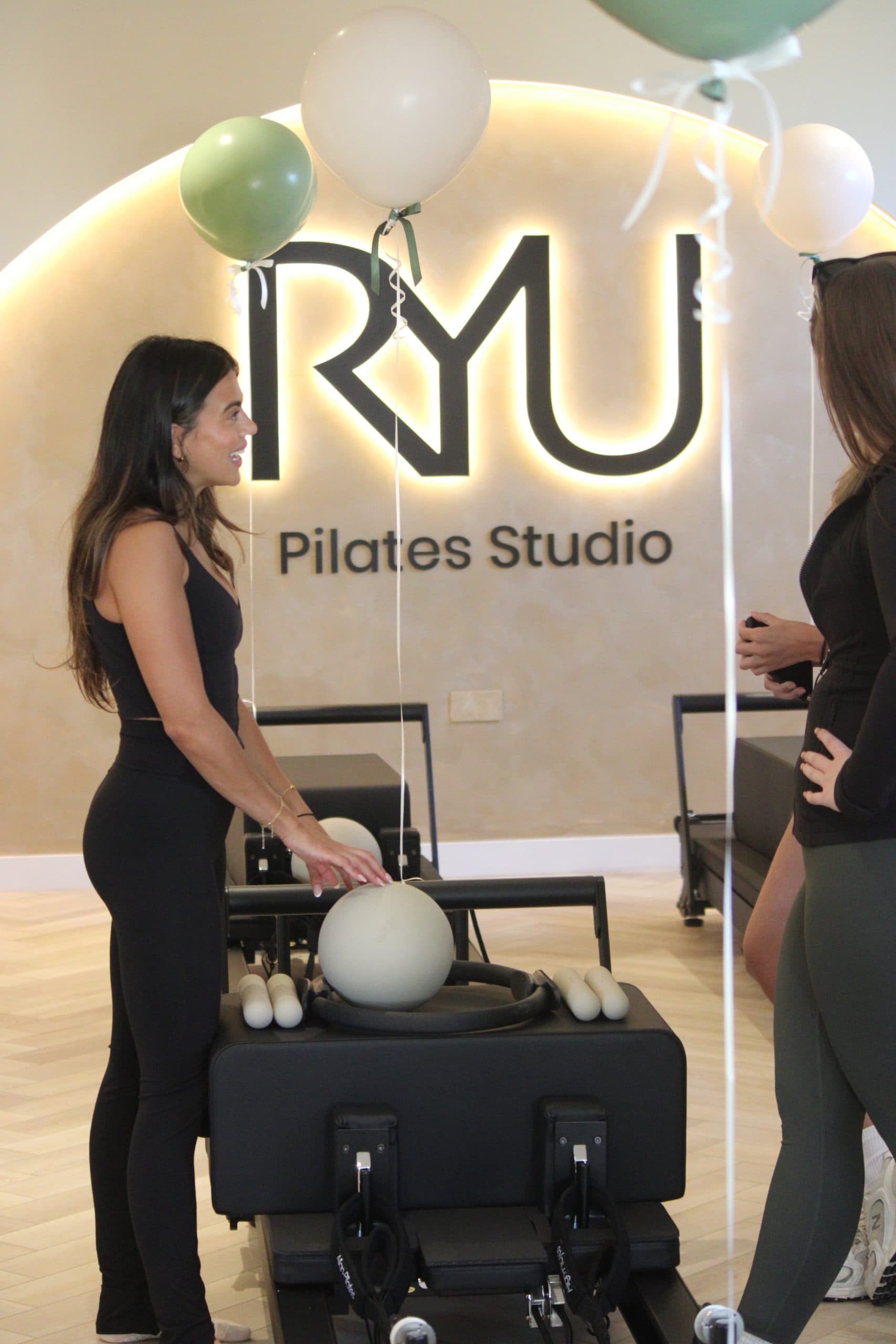 Reform YU instructor and member chatting beside a reformer